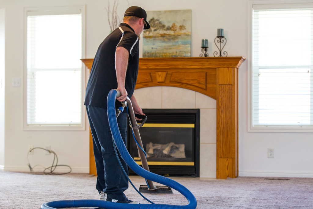 A person vacuuming a carpet inside a home, performed by Chinook Services Silver Lake in Everett, WA