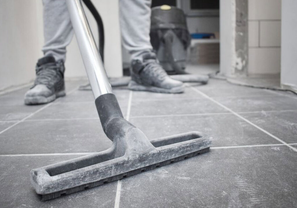 A person vacuuming a tiled floor, showcasing professional house cleaning services by Essential Cleaning in Henderson, NV.