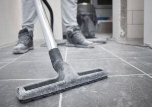 A person vacuuming a tiled floor, showcasing professional house cleaning services by Essential Cleaning in Henderson, NV.
