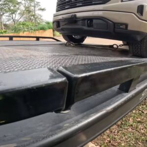 A pickup truck securely chained onto a flatbed tow truck by Columbus Towing in Columbus, GA.