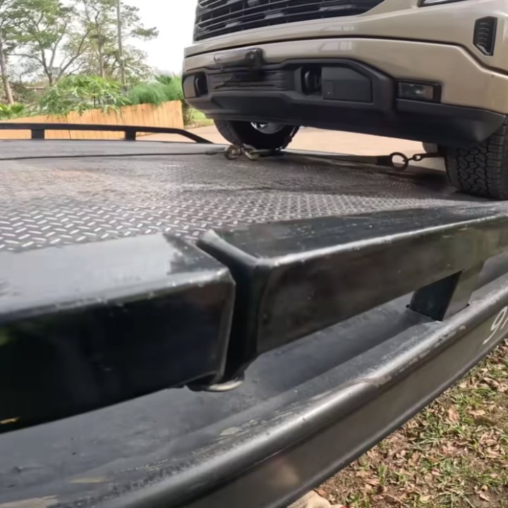 A pickup truck securely chained onto a flatbed tow truck by Columbus Towing in Columbus, GA.