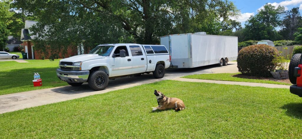 A white pickup truck towing a large white enclosed trailer for Inglewood Transmission in Long Beach, CA.