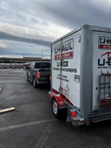 A pickup truck towing a U-Box moving container, representing services by The Knoxville Moving Co. in Knoxville, TN.