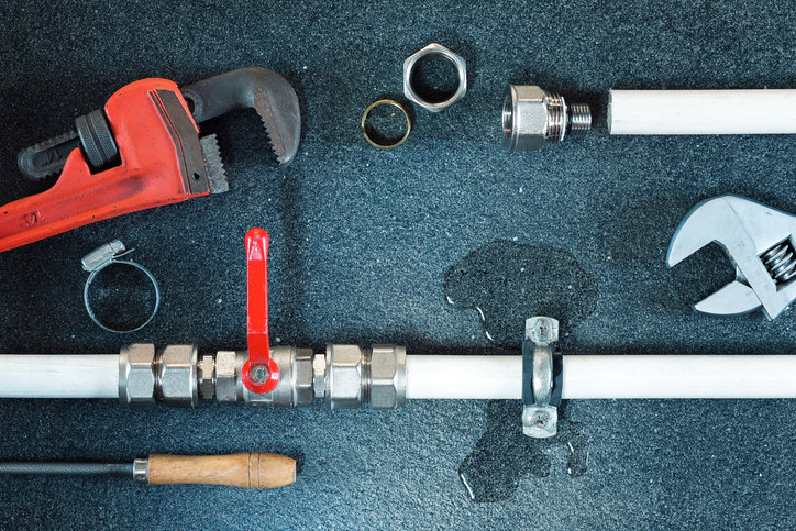 Plumbing leak repair with tools and visible water damage by Clog Busterz Plumbing Services in Richmond, KY.