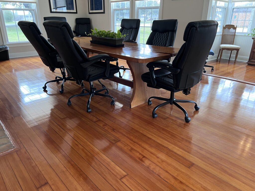 A beautifully polished hardwood floor in a home dining room, expertly cleaned by JBO Cleaning Services in Belle Chasse, LA.