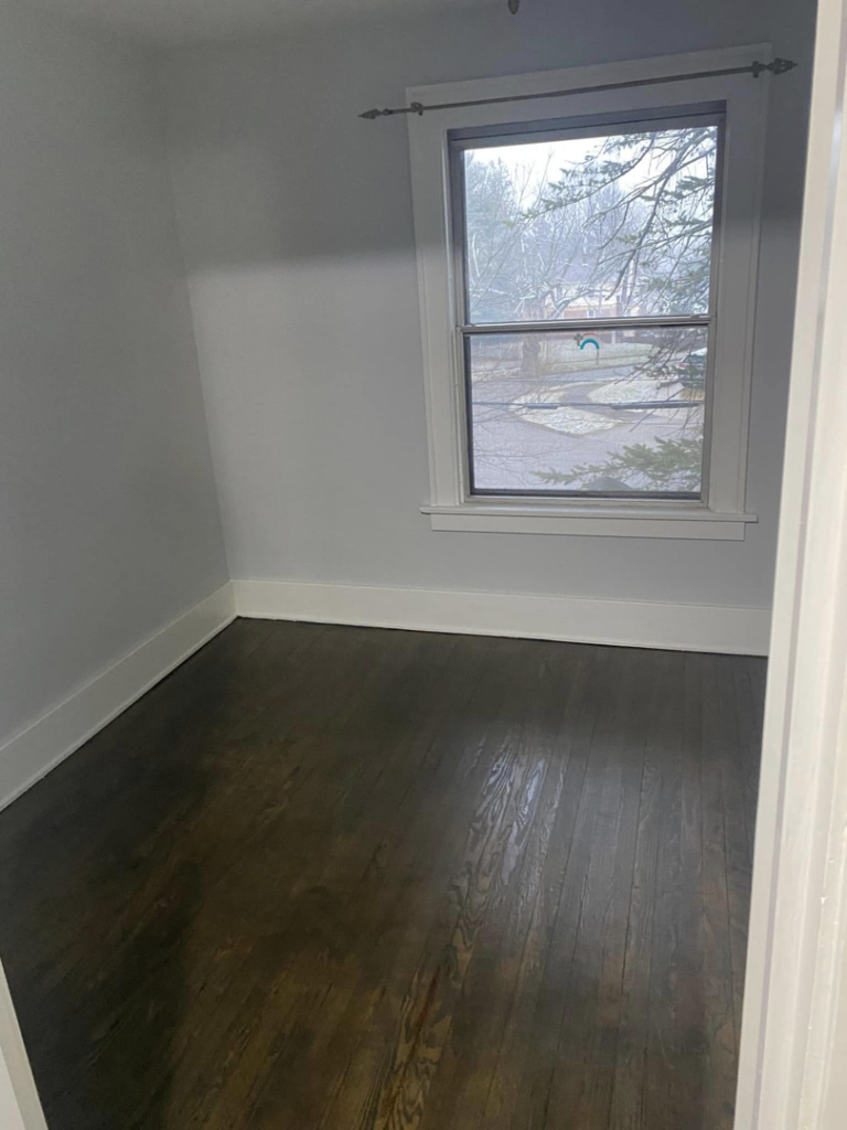 A sparkling clean and polished hardwood floor in an empty room by Kings and Queens of the Most High Cleaning Services in Akron, OH.