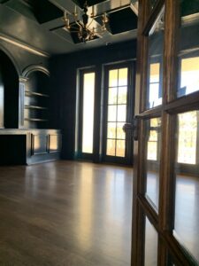 A highly polished dark hardwood floor reflecting light, demonstrating the floor cleaning services of Simply Clean Jax in Jacksonville, FL.