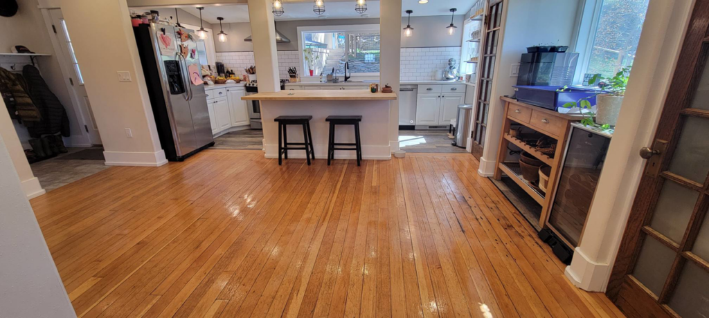 Beautifully polished hardwood floors leading into a clean kitchen, a result of Rachel Blume Residential Cleaning Specialist's work in Sheridan, WY.