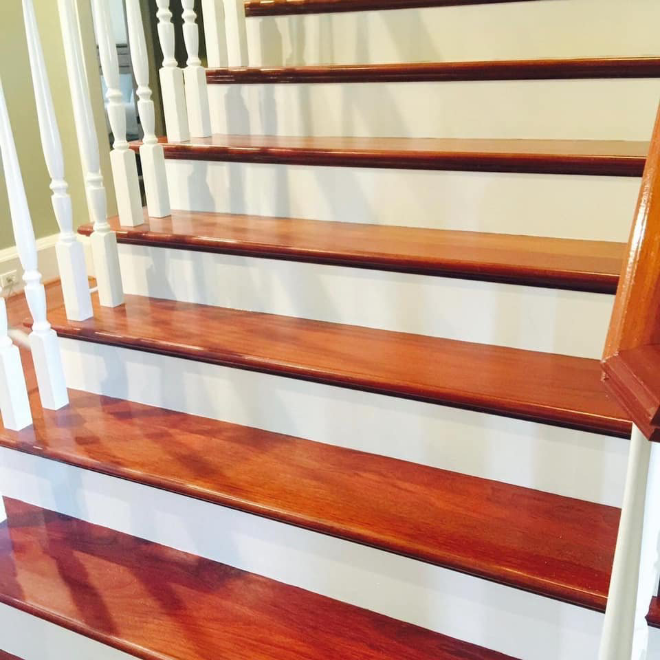 A beautifully polished wooden staircase with white risers, showcasing house cleaning by A'La Carte Clean in Virginia Beach, VA.