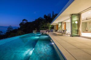 A pool cleaner actively cleaning a swimming pool with a long pole, providing service for Priority Pools LV in Las Vegas, NV
