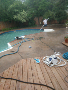 A pool cleaner vacuuming a residential swimming pool for Danny's Pool Service in Stillwater, OK.