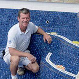 A pool contractor installing a new liner or tiles in a swimming pool for NATURAL SALT POOLS LLC in Kailua, HI.