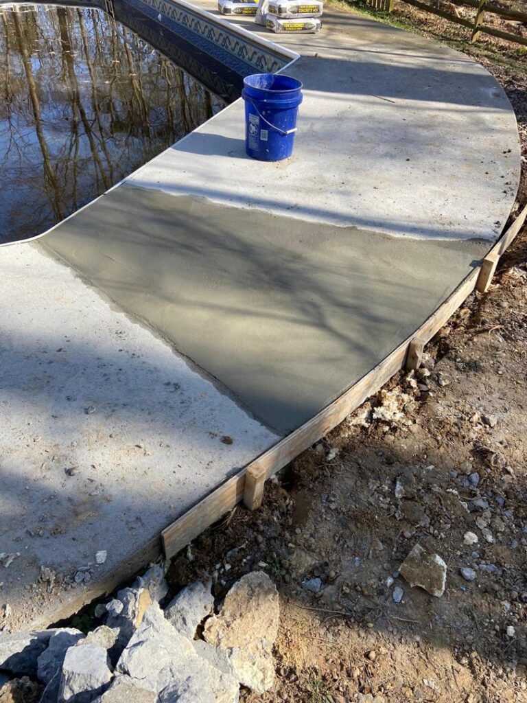 Fresh concrete being applied for repair or leveling around a pool deck by HNO Waterproofing & Slab Lifting Pros in Concord, NC.