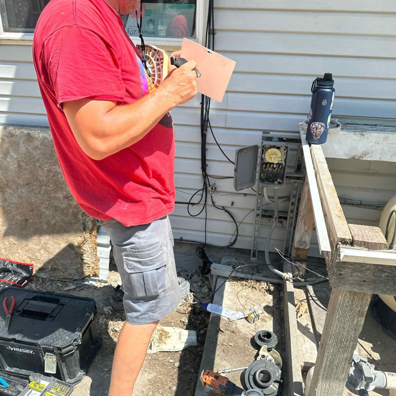 A technician inspecting pool equipment and electrical systems for Retrowave Pool & Spa in Nampa, ID.