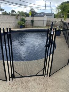 A close-up of a pool fence gate installation by Guardian Pool Fence Systems of Hawaii, ensuring secure access to a pool in Honolulu, HI.