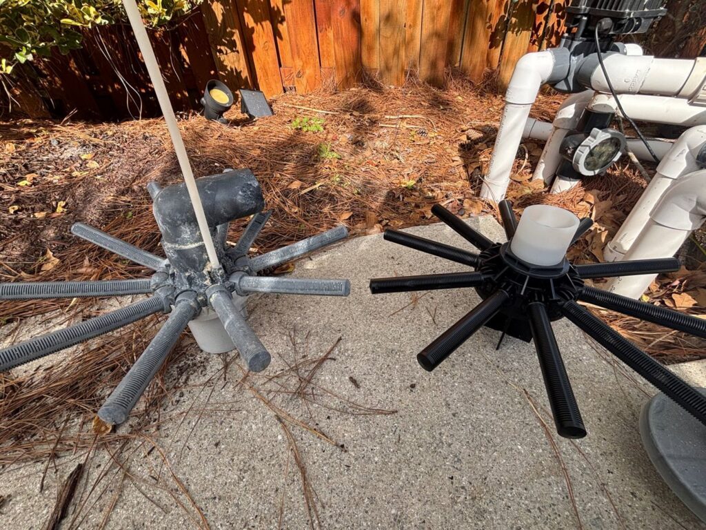 In-floor pool cleaning system components next to a pump, maintained by Pool Services of Wilmington in Wilmington, NC.