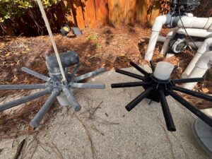In-floor pool cleaning system components next to a pump, maintained by Pool Services of Wilmington in Wilmington, NC.