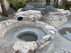 A pool rock waterfall feature under construction, showing the framework and rock placement by Fix A Pool in Las Vegas, NV