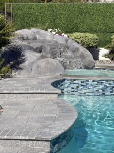 A beautiful pool with a natural rock waterfall and a tiled spa by Laguna Pool & Spa and Landscaping in Las Vegas, NV