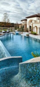 A pool vacuum hose and pole actively cleaning a residential pool by Vegas Integrity Pool Service in Las Vegas, NV.