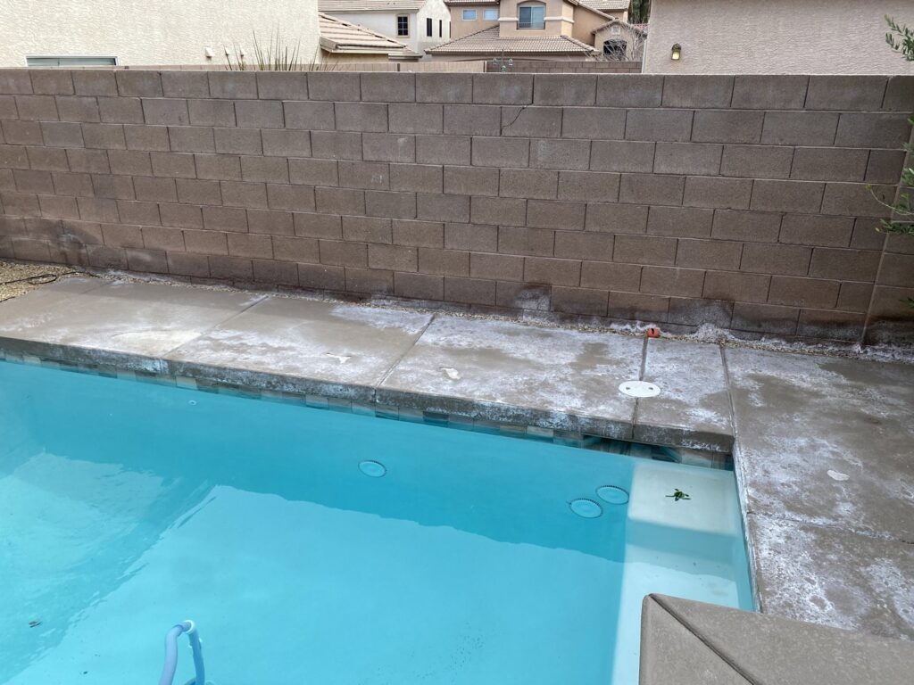 A swimming pool showing a dirty waterline and stained concrete decking, indicating need for service from Fix A Pool in Las Vegas, NV