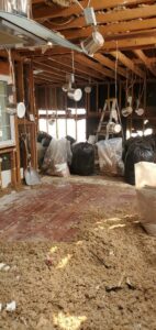 A room stripped to studs with insulation debris on the floor after water damage remediation by Bordi Restoration in San Leandro, CA