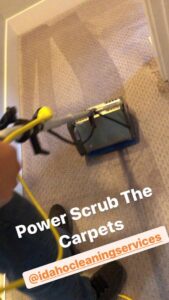 A house cleaner from Idaho Gem Cleaning power scrubbing carpets with a cleaning machine in Caldwell, ID.