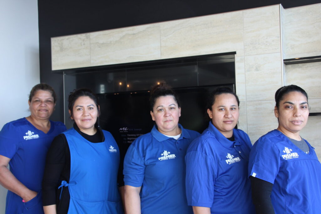 The professional cleaning team of Premier Uptown Clean in Charlotte, NC, wearing their blue uniforms