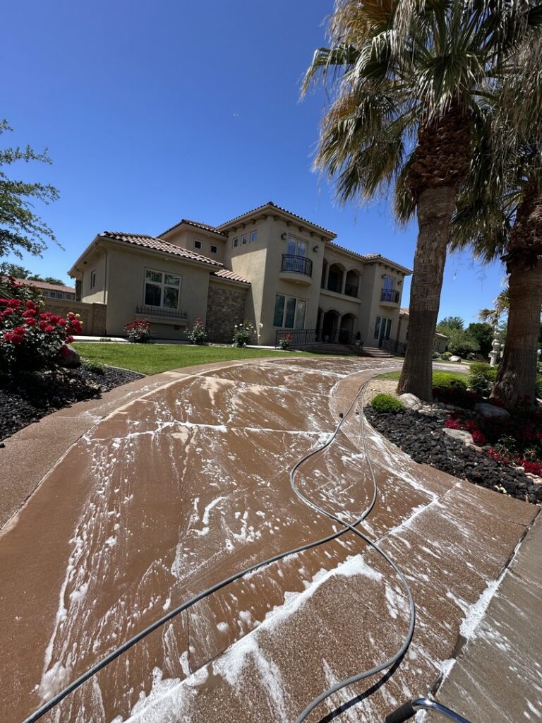 A residential driveway being pressure washed with soap by Farki Pressure Washer LLC in Mesquite, NV