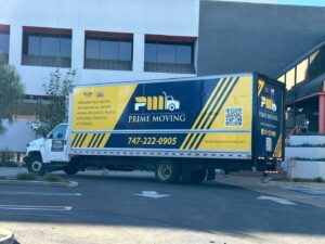 A branded Prime Moving truck parked outside a commercial building, ready for service in Boston, MA.