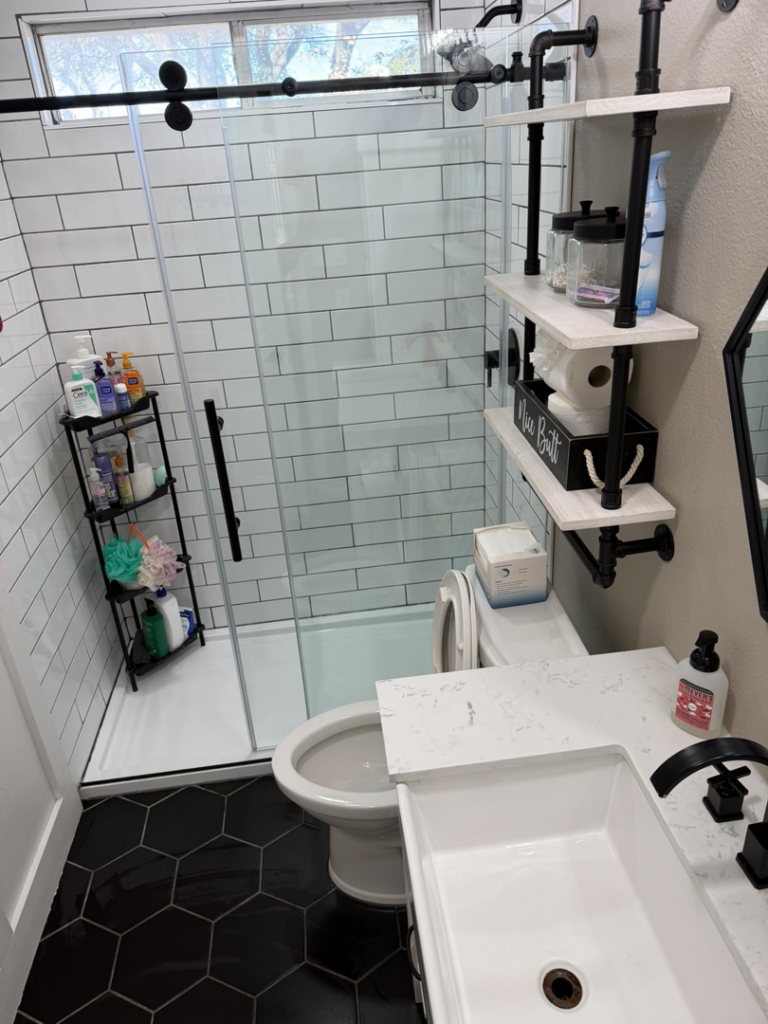 A pristine bathroom featuring a clean shower, toilet, and sink, expertly cleaned by Lupita's cleaning services in San Antonio, TX.