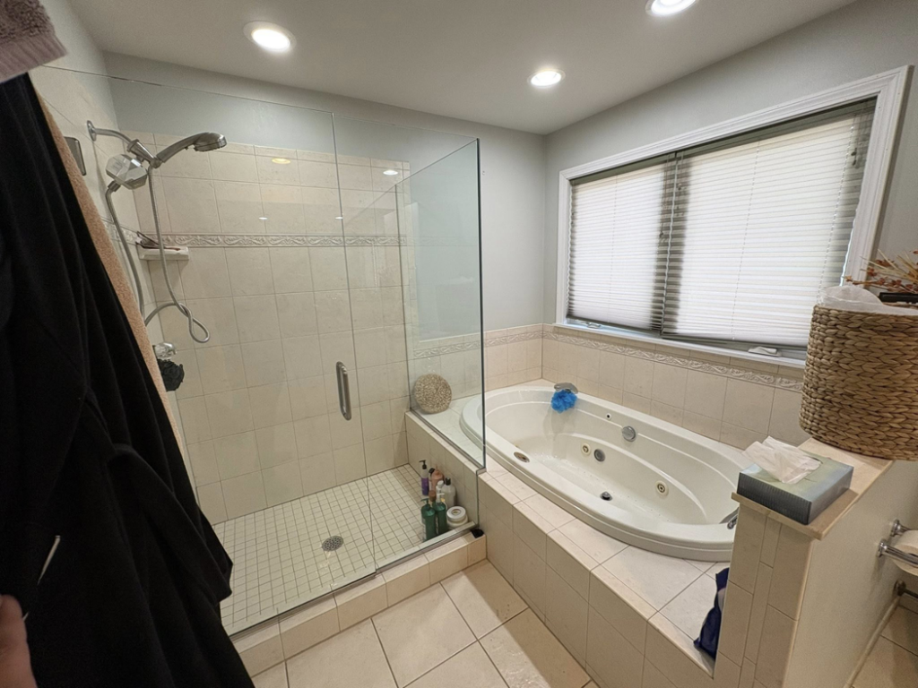 A pristine bathroom featuring a clean glass shower and a large jetted tub, cleaned by HDew Cleaning Co. in Madison Heights, MI.