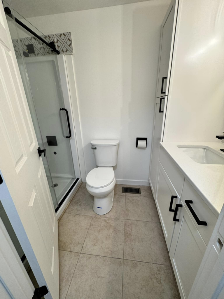 A pristine bathroom with a clean shower, toilet, and vanity, cleaned by Dust Detail Cleaning Services in Post Falls, ID.