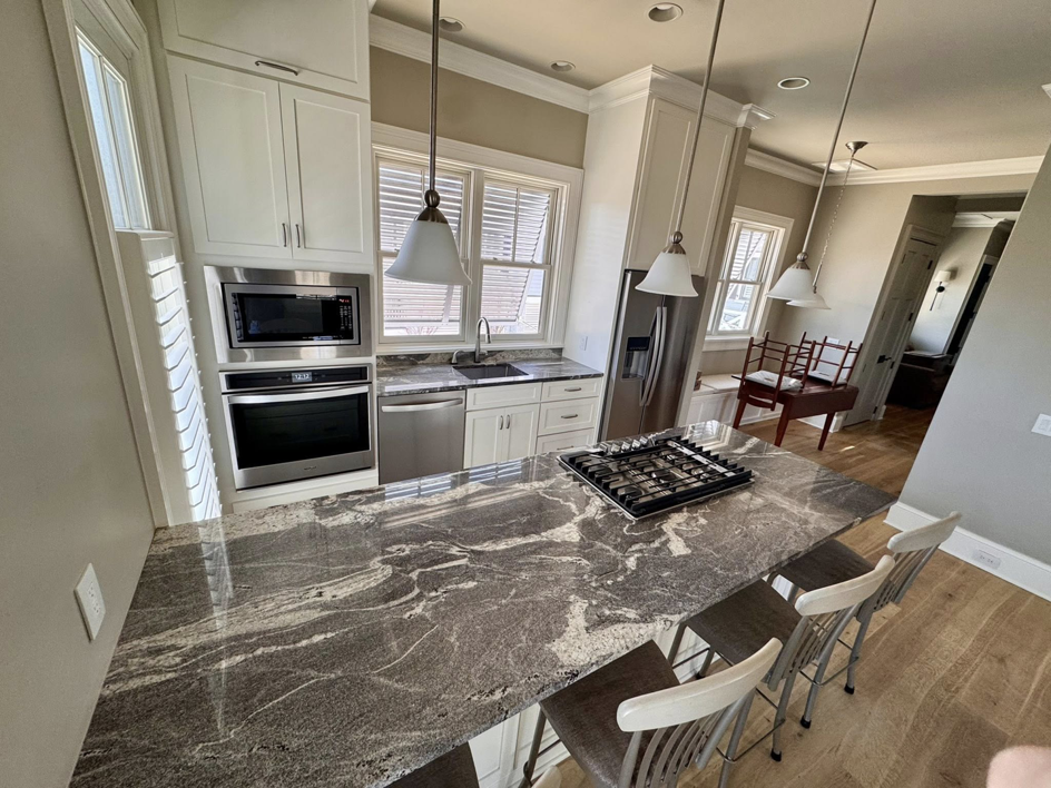 A pristine kitchen island with a polished granite countertop and clean appliances by Affordable Cleaning in North Charleston, SC.