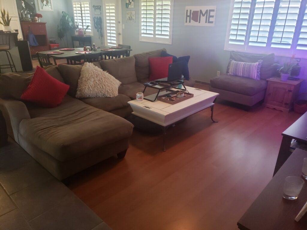 A pristine living room with gleaming hardwood floors and neatly arranged furniture, showcasing A Clean Xscape LLC's house cleaning in Chandler, AZ.