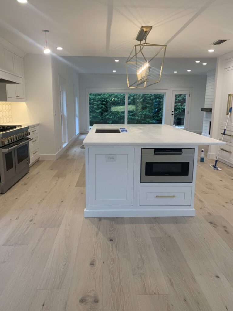 A pristine modern kitchen with a large island and clean surfaces, showcasing the work of Simply Clean Jax in Jacksonville, FL.