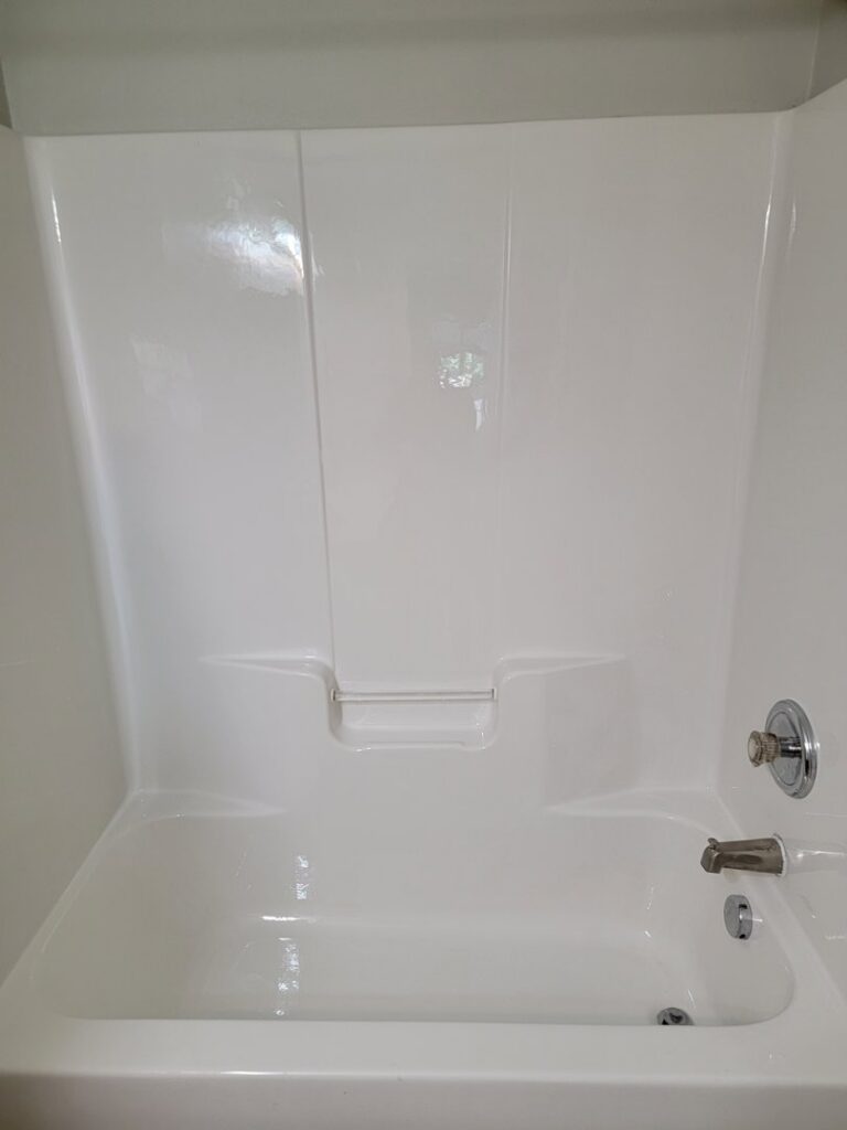 A pristine white bathtub and shower unit, showcasing the thorough bathroom cleaning by AG Simply Clean in Concord, NC.
