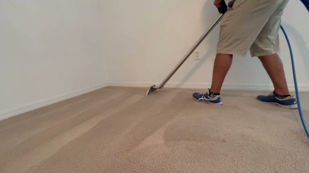 A professional house cleaner performing carpet cleaning with a wand in a residential home by Cleaning Partners in Tampa, FL