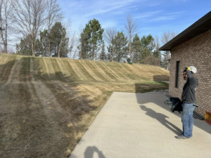 Professional lawn mowing on a large sloped yard with fresh stripes by Top Cut Lawn Care and Snow Removal in Minot, ND.