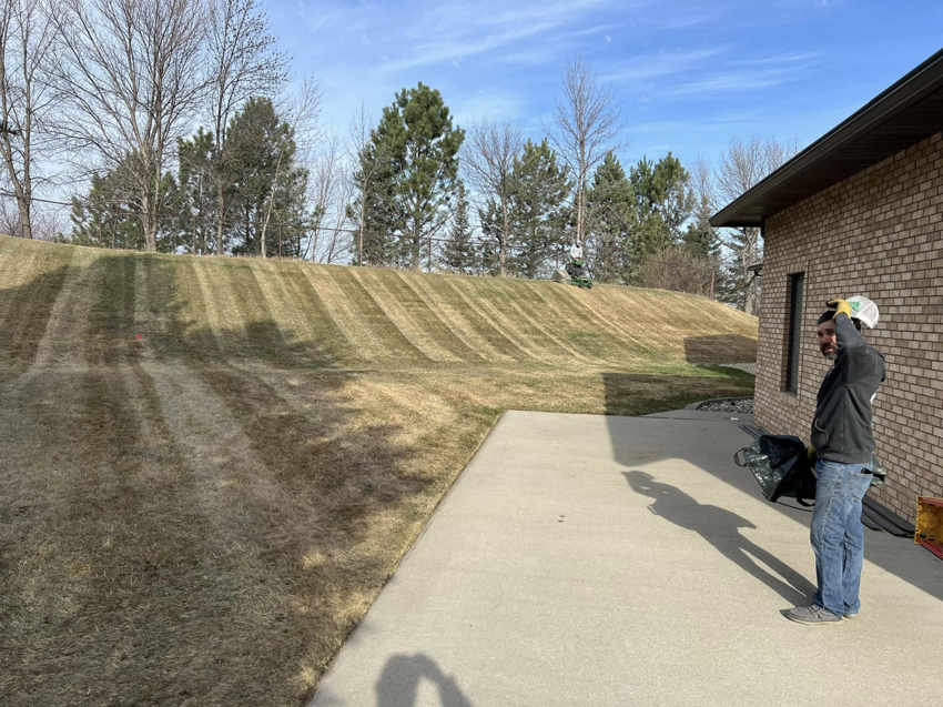 Professional lawn mowing on a large sloped yard with fresh stripes by Top Cut Lawn Care and Snow Removal in Minot, ND.