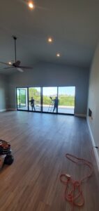 Professional cleaners meticulously cleaning large windows in a home, provided by Rubber Gloves Residential Cleaning in San Antonio, TX.