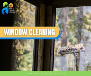 A professional cleaning a window with a squeegee tool for Paynes Cleaning Solutions in Charlotte, NC