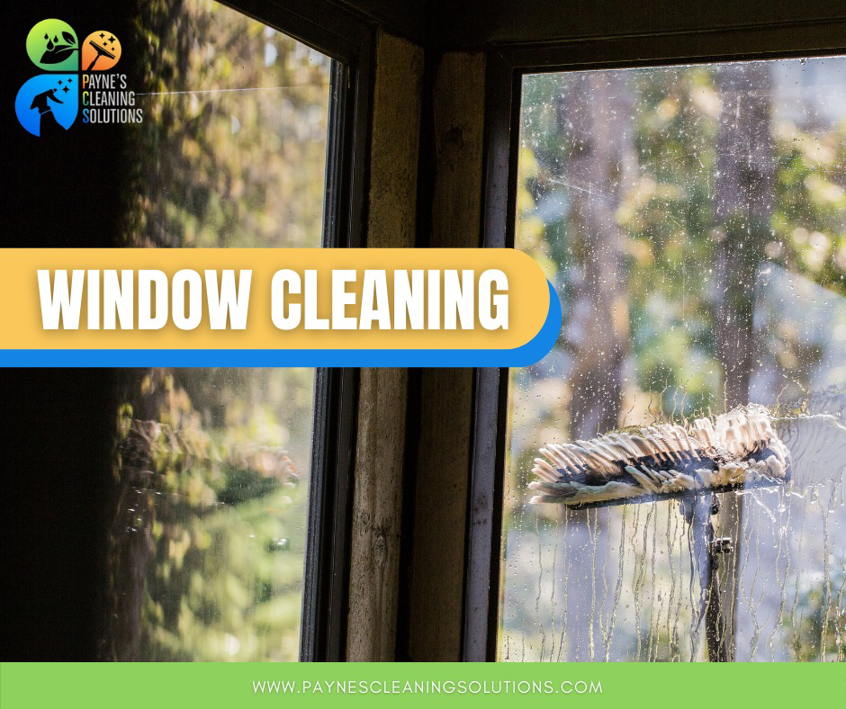 A professional cleaning a window with a squeegee tool for Paynes Cleaning Solutions in Charlotte, NC