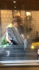 A professional performing window cleaning service, seen through a soapy window, by Idaho Gem Cleaning in Caldwell, ID.