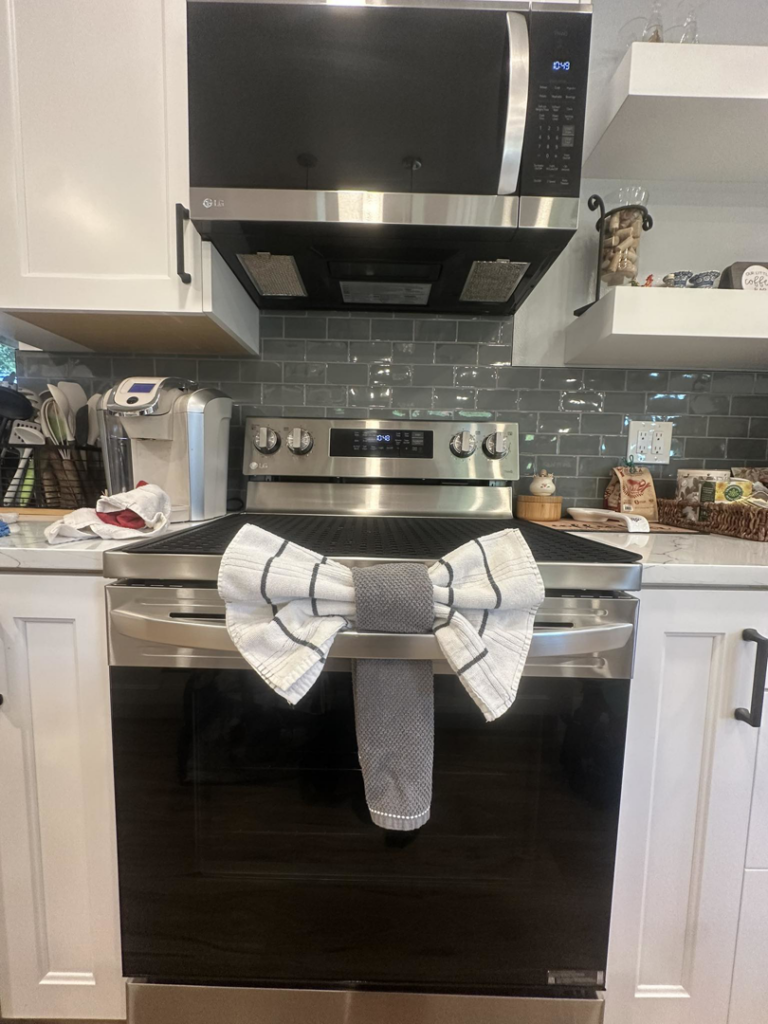 A professionally cleaned kitchen stove and microwave with a decorative towel by Green & Simple LLC in Puyallup, WA.
