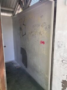 A public restroom wall covered with graffiti before cleaning by EB Restorations & Cleaning Services in Sparks, NV