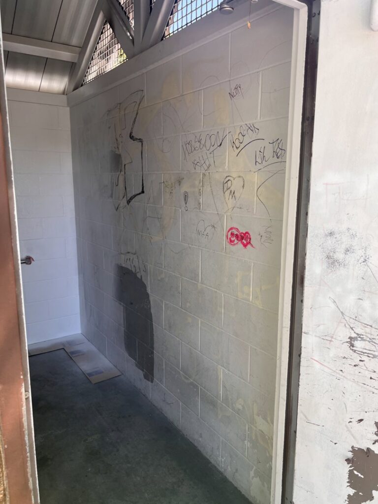 A public restroom wall covered with graffiti before cleaning by EB Restorations & Cleaning Services in Sparks, NV