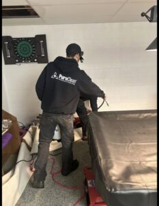 A PuroClean technician spraying a basement area as part of water damage remediation in Lancaster, PA.