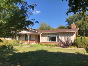 A ranch-style house with light-colored horizontal siding and brick, expertly installed by Urban Exteriors LLC in Lakewood, CO.