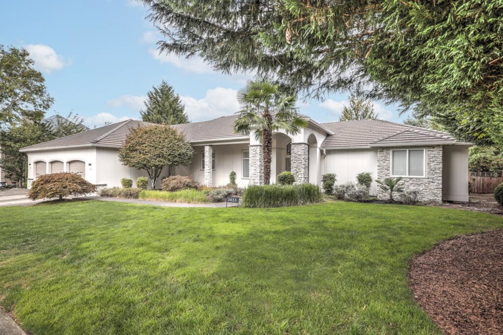 A ranch-style house with light-colored siding and stone accents by Lifetime Remodeling Systems in Portland, OR.